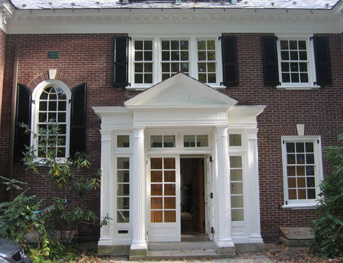 front of home with pedimented white entrance 
