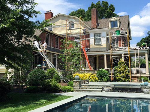 photo of rear of Victorian home in Chestnut with pool in foreground in process of being painted
