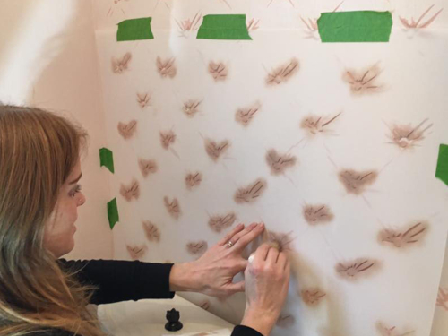 photo of Emilie Stulb Magowan hand-painting design on wall to reproduce damaged wallpaper