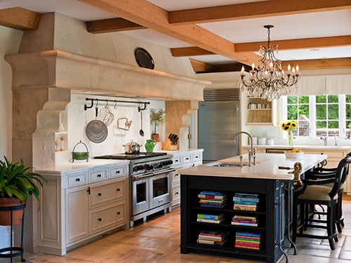 photo of kitchen with cooking area to left and island in foreground, exposed beams on ceiling