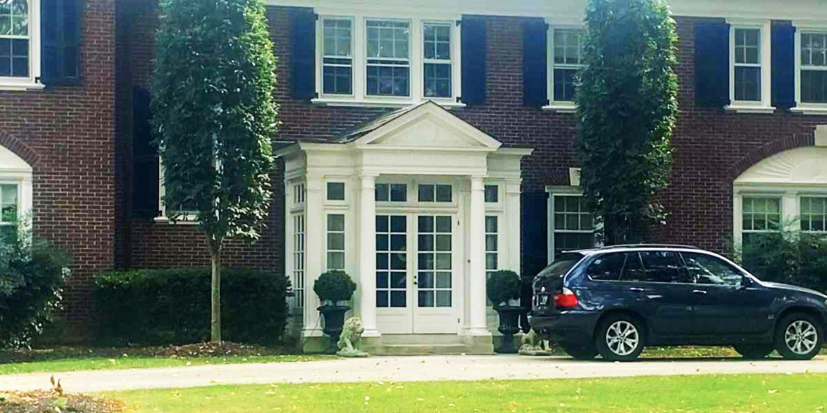 photo of glass portico with frence doors on brick home