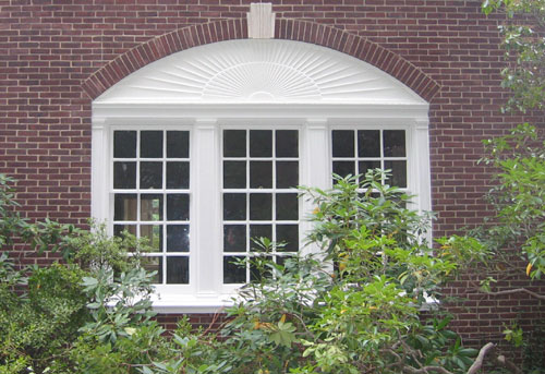 photo of 3 window in brick wall with sunburst above