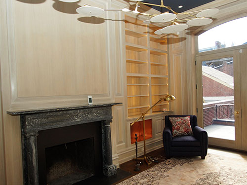 photo of library with fireplace, bookshelves and oak paneling with wood wash finish