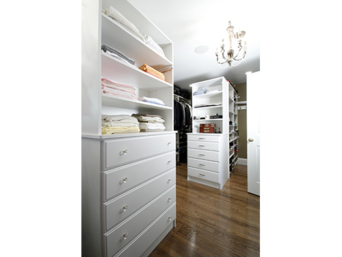 photo of walk-in closet with white shelving and cabinets